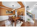 Elegant dining room featuring wood floors, wainscoting, decorative ceiling, and stylish furnishings perfect for entertaining at 1612 Rainesview Ln, Apex, NC 27502