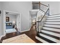 Bright foyer showcasing hardwood floors, an elegant staircase with iron railings, and modern gray wall paint at 1637 Dodford Ct, Wake Forest, NC 27587