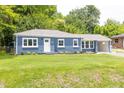 Inviting blue brick house featuring well-maintained landscaping, covered parking, and a green lawn at 1917 Tucker St, Burlington, NC 27215