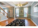 Elegant living room with hardwood floors, crown molding, and a stylish chandelier at 1937 Crag Burn Ln, Raleigh, NC 27604