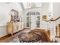 Bright foyer showcasing a decorative cabinet, rug, and staircase leading to upper level at 20007 Bragg, Chapel Hill, NC 27517