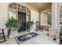 A cozy front porch with flagstone, potted plants, and a rocking chair evokes a welcoming feeling at 20007 Bragg, Chapel Hill, NC 27517
