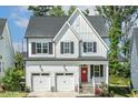 Charming two-story home featuring a two-car garage, a red front door, and a well-manicured lawn at 208 Dry Canyon Dr, Wendell, NC 27591
