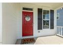 Inviting front porch featuring a vibrant red door with a charming wreath and a cozy welcome mat at 208 Dry Canyon Dr, Wendell, NC 27591