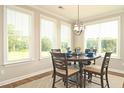 Bright breakfast nook with large windows offering backyard views, modern lighting, and seating for four at 3002 Dog Rose Dr # 310, Durham, NC 27703