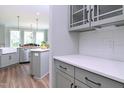 Modern kitchen featuring stainless steel appliances, subway tile backsplash, gray cabinets and countertops, and a breakfast bar at 3002 Dog Rose Dr # 310, Durham, NC 27703