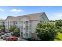 A low-angle shot of a three-story residential building with white balconies and ample parking at 3015 Winston Dr # 117, Burlington, NC 27215