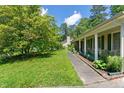 A view of the side yard featuring a well-maintained lawn, mature trees, and a sidewalk at 305 Reynolds N Ave, Durham, NC 27707