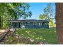 Spacious backyard with a well-maintained lawn, surrounded by lush trees and natural landscaping at 308 Lynn Road, Durham, NC 27703