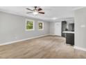 Bright living room featuring hardwood floors, ceiling fan, and access to a modern kitchen at 308 Lynn Road, Durham, NC 27703