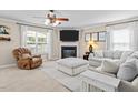Cozy living room with a fireplace, fan, neutral tones, and lots of natural light at 3169 Diana Cir, Burlington, NC 27215