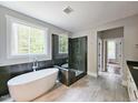 Bright bathroom features soaking tub, walk-in shower, and views of wooded property at 35 Big Bear Dr, Pittsboro, NC 27312