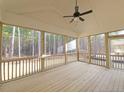 Covered porch with screened windows and ceiling fan overlooking wooded backyard at 35 Big Bear Dr, Pittsboro, NC 27312
