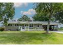 Charming brick ranch with a white picket fence, covered porch, and attached carport at 444 Barnette Rd, Louisburg, NC 27549