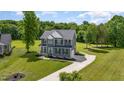 Aerial view of a gray two-story house with a long driveway and large green lawn at 45 Leighann S Ct, Timberlake, NC 27583