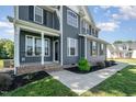 Inviting front porch with dark gray siding, white trim, and manicured landscaping at 45 Leighann S Ct, Timberlake, NC 27583
