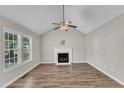 Bright living room featuring a fireplace, vaulted ceiling, and natural light from large windows at 4533 Whistling Way, Raleigh, NC 27616
