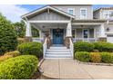 Inviting front porch with stone accents, white railings, and a charming blue double-door entrance at 4562 Brighton Ridge Dr, Apex, NC 27539