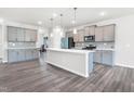 Spacious kitchen with an island, modern appliances, ample counter space, and gray cabinets at 4601 Okeechobee Ct, Fuquay Varina, NC 27526