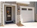 Inviting front entrance with stone detail, glass paneled front door, and attached garage at 509 Sherron Rd # 11, Durham, NC 27703
