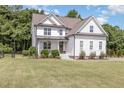 Charming two-story white farmhouse-style home with well-maintained lawn and landscaping creating a welcoming curb appeal at 5180 Old Powell Rd, Holly Springs, NC 27540