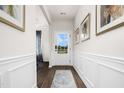 Bright entryway featuring wood-look floors, white wainscoting, art, and a glass-paned front door at 55 E American Marigold Dr # 36, Benson, NC 27504