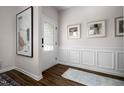 Inviting entryway boasts wood-look floors, wainscoting, a glass-paned door, and decorative wall art at 55 E American Marigold Dr # 36, Benson, NC 27504