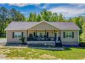 Inviting one-story home with black shutters, a porch with rocking chairs, and brick trim at 5912 Mt Zion Rd, Snow Camp, NC 27349