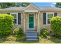 Close-up of a home's front door with stone accents and decorative shutters at 701 Veterans Dr, Elon, NC 27244