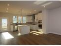 Bright kitchen featuring stainless steel appliances, large island, and white cabinets at 806 Hillfarm Dr, Wake Forest, NC 27587