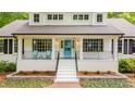Inviting home with bright blue door framed by large windows and flanked by classic columns at 823 Churchill Dr, Chapel Hill, NC 27517