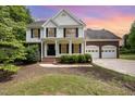 Charming two-story home featuring a covered porch and a two-car garage at dusk at 84 Sycamore Lake Rd, Siler City, NC 27344