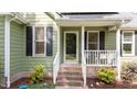 Inviting entrance with green siding, white railing, and address number above the black front door at 909 Alderleaf Dr, Fuquay Varina, NC 27526
