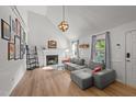 Bright living room with high ceilings, fireplace, wood floors, and a comfortable gray sectional sofa at 909 Alderleaf Dr, Fuquay Varina, NC 27526