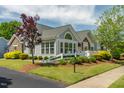 Attractive gray home featuring stone accents, well-maintained landscaping, and a charming white picket fence at 924 Carolina Bell Rd, Apex, NC 27502