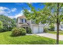 Charming two-story home with a two car garage, manicured lawn, and stone walkway at 10 Marsh Landing Ct, Durham, NC 27703