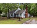 Inviting cottage home featuring a classic brick chimney, shingle siding, and a well-manicured lawn at 1100 Cardinals Knob, Rocky Mount, NC 27804