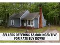 Charming cottage-style home with a brick chimney, mature trees, and blue siding at 1100 Cardinals Knob, Rocky Mount, NC 27804