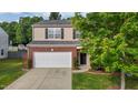 Charming two-story home with brick accents, a two-car garage, and landscaped front yard at 1301 Torrey Pines Ct, Mebane, NC 27302