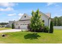 Beautiful home with a three-car garage, green lawn and manicured landscaping at 164 Wilson Farm Ln, Clayton, NC 27527