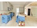 Bright kitchen area with gray cabinets, an island, stainless steel faucet, and an open floor plan at 188 Buckaroo Dr, Louisburg, NC 27549