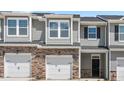 Close up of an exterior elevation of a new townhome showing stone accents and one car garage at 1903 Hinesley Dr, Durham, NC 27703