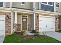 Close up of a townhouse front door, showing stone detail and a one car garage at 1905 Hinesley Dr, Durham, NC 27703