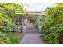 View of the home showcasing its inviting front porch with beautiful flowering vines and lush greenery at 206 N State St, Raleigh, NC 27601