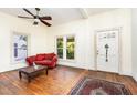 Inviting living room with a red sofa, hardwood floors, ceiling fan and two windows at 206 N State St, Raleigh, NC 27601