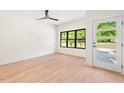 Bright bedroom features hardwood floors, a modern ceiling fan, and a large window with natural light at 2205 Tampa Ave, Durham, NC 27705