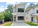 Contemporary two-story home with a gray exterior, modern design elements, and green lawn at 2205 Tampa Ave, Durham, NC 27705