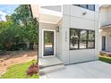 Home front entry featuring a modern, sleek design with a glass-paneled door and well-maintained landscaping at 2205 Tampa Ave, Durham, NC 27705