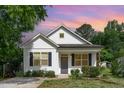 Charming home featuring a gray door, black shutters, and lush lawn at sunset at 303 Godwin St, Selma, NC 27576