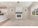Bright open-concept living room featuring modern fireplace and adjacent to kitchen at 303 Godwin St, Selma, NC 27576